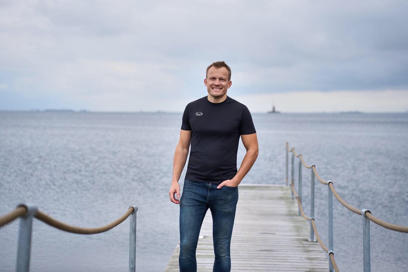 Thomas Jørgensen på en badebro med havet og en overskyet himmel bag sig