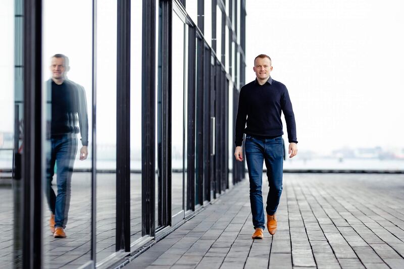 Thomas Jørgensen går langs en glasfacade ved vandet